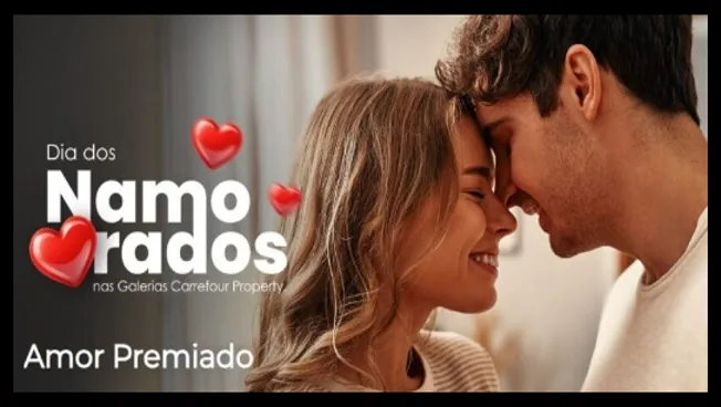 A imagem mostra um casal jovem e apaixonado, em um momento íntimo e afetuoso, com as testas encostadas e expressões de felicidade. O fundo desfocado remete a um ambiente acolhedor. Corações vermelhos decoram a cena, reforçando o clima romântico. Do lado esquerdo, está o texto promocional “Dia dos Namorados nas Galerias Carrefour Property – Amor Premiado”, destacando a campanha especial em celebração à data.
