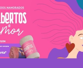 Casal feliz segurando manta exclusiva da promoção de Dia dos Namorados 2025 no Shopping Frei Caneca, com banner promocional ao fundo indicando a troca do brinde nas compras a partir de R$350.